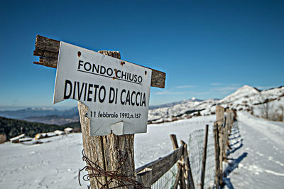 Information sign on wooden post against sky