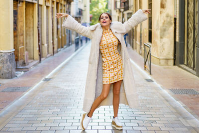 Portrait of young woman standing on street