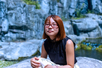 Young woman sitting on rock