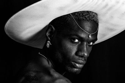Close-up portrait of young man against black background