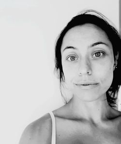 Portrait of smiling young woman against white background