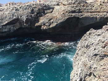 Rock formations by sea against sky