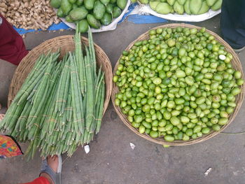 Low section of woman standing in front of vegetables at street market