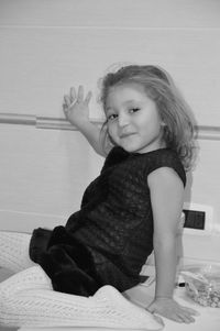 Portrait of smiling cute girl sitting on floor at home