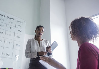 Businesswoman with female colleague discussing at office