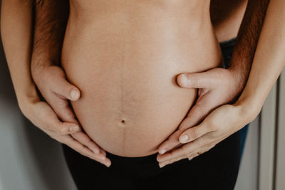 Midsection of couple embracing at home