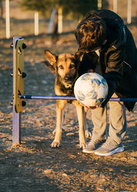 Child and dog. boy plays and teaches  dog to jump over obstacles