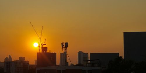 Silhouette buildings against sky during sunset