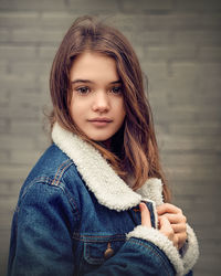 Portrait of girl wearing denim jacket standing outdoors