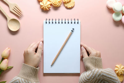 Cropped hand of woman holding gift on table