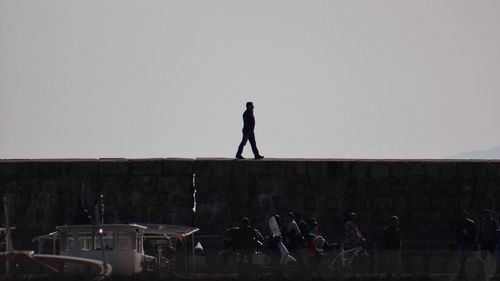 People standing in front of built structure against clear sky