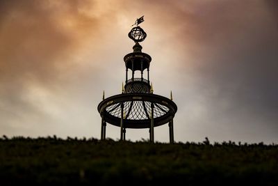 Low angle view of tower on field against sky