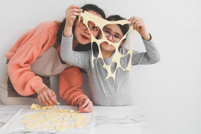 Two girls are preparing homemade cookies.