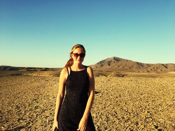 Portrait of woman standing on land against sky