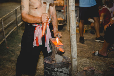 Midsection of man holding fire hydrant