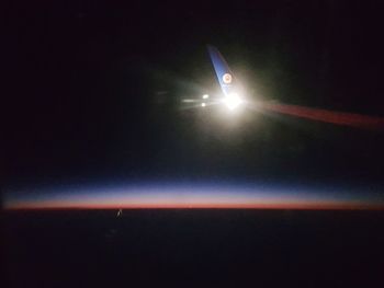 Airplane wing against sky at night