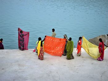 Rear view of people by sea