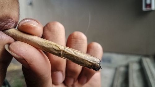 Close-up of hand holding cigarette