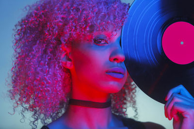 Portrait of young woman with curly hair holding vinyl