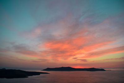 Scenic view of sea against dramatic sky during sunset