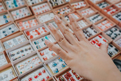 Cropped image of woman choosing artificial fingernails in store