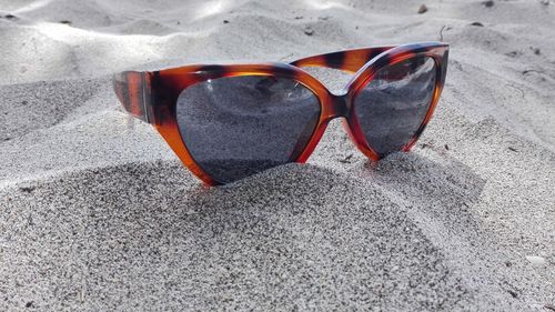 High angle view of sunglasses on sand