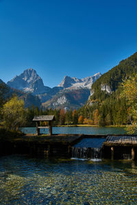 Scenic view of lake against clear blue sky