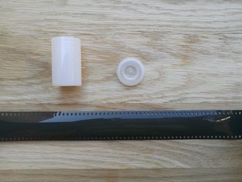 Directly above shot of plastic container by film reel on table