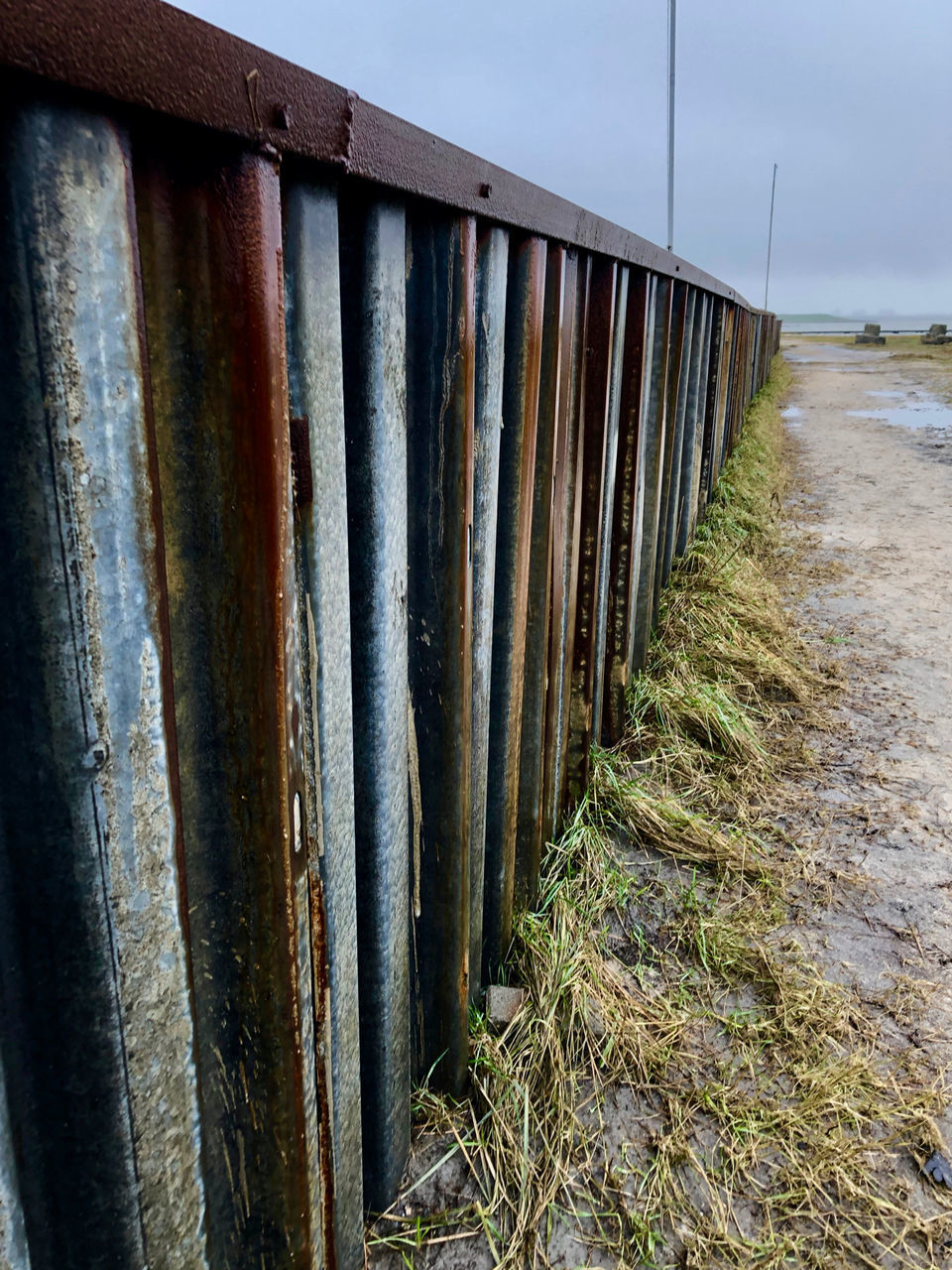 RUSTY METAL FENCE ON LAND