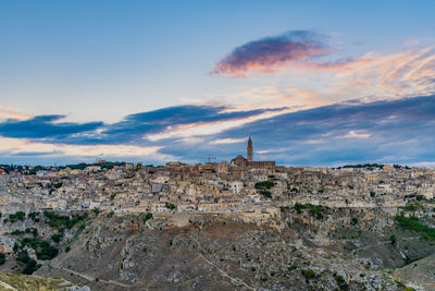 View of sassi di matera against cloudy sky during sunset