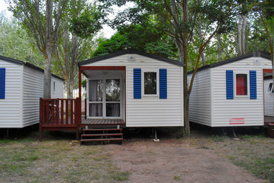 House by trees on field against building