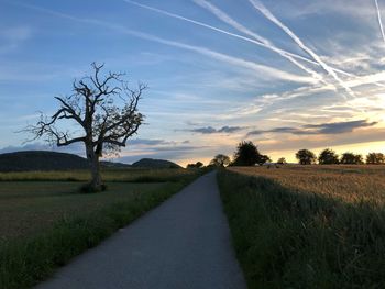 Road amidst field against sky