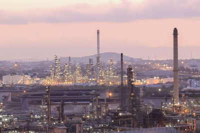 Illuminated factory against sky at night