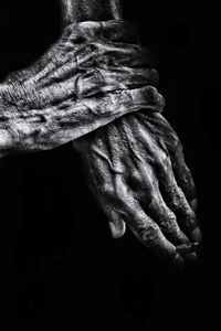 Close-up of human hands against black background