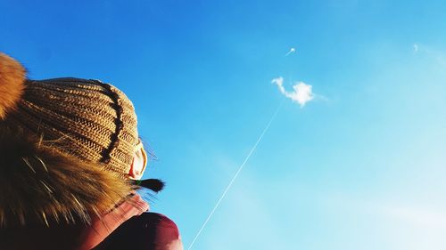 Low angle view of woman against blue sky