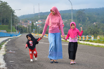 Full length of mother and girl on road