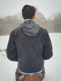 Rear view of man standing on snow field