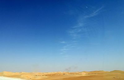Scenic view of desert against clear blue sky