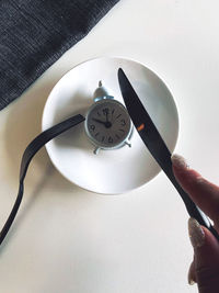 Close-up of hand holding clock