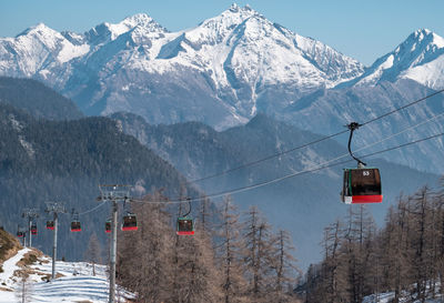 Overhead cable car over snowcapped mountains against sky