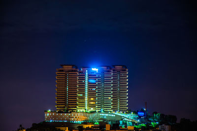 Illuminated buildings against sky at night