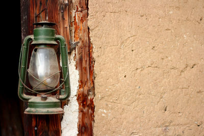 Close-up of old lantern hanging against wall