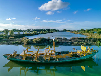 Boats moored in lake against sky