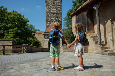 Full length rear view of woman walking on footpath