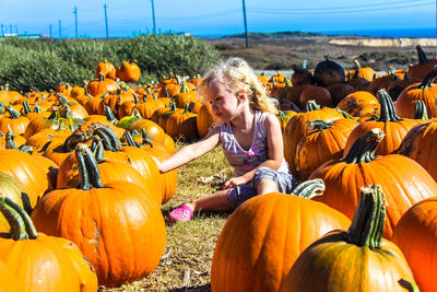 Full length of girl on pumpkin field