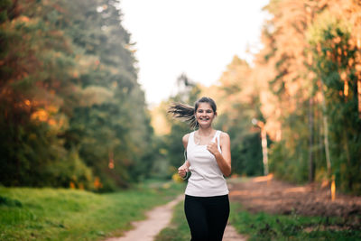 Woman standing on field against trees