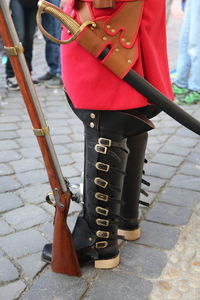 Low section of person wearing uniform while standing in city