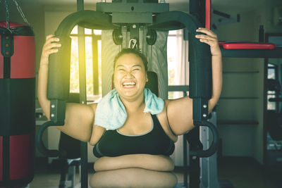 Happy young woman exercising at gym
