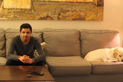 Portrait of man sitting on sofa at home