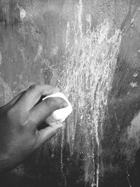 Close-up of hand holding raindrops on water